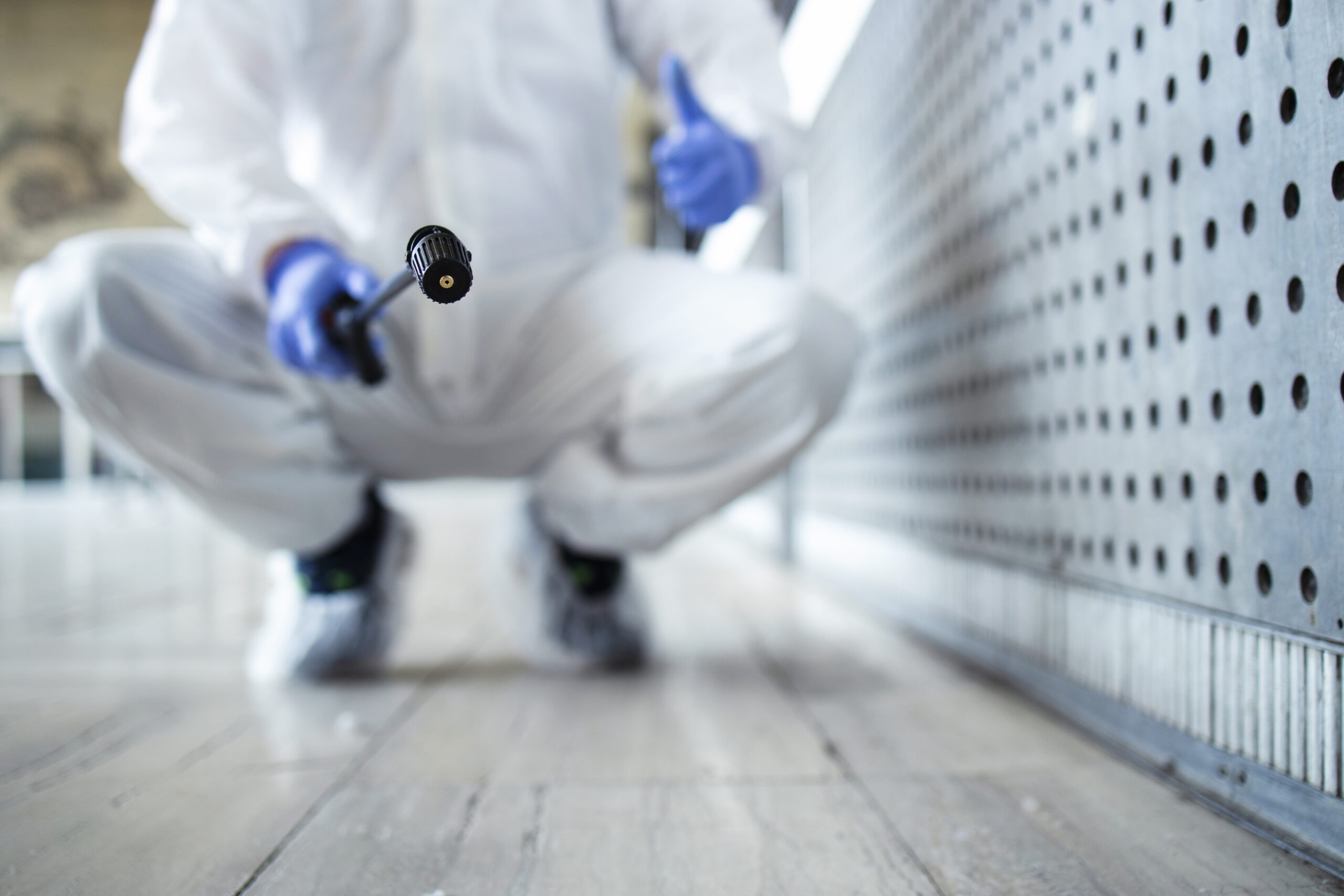 White suit pest control worker spraying for pest elimination | Rat Trap Experts Ilford, London